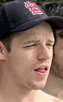 a man wearing a baseball cap with the word angels on it is making a face .