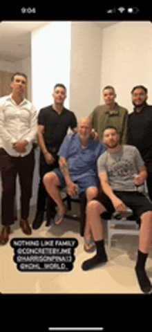 a group of men are posing for a picture and one of them is sitting in a chair .