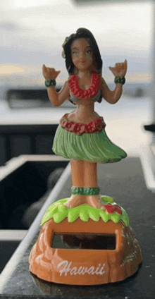 a figurine of a hula dancer from hawaii is sitting on a counter