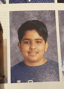 a boy in a blue shirt with the letter n on the front