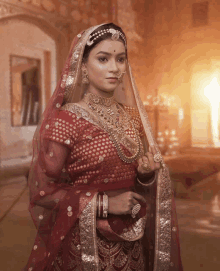 a woman in a red and gold dress and veil