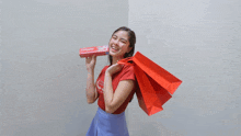 a woman holding a colgate toothpaste and shopping bags