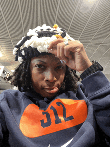 a woman wearing a hat and a nike hoodie