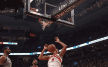 a basketball player with the number 4 on his jersey shoots a basket