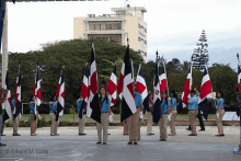 a group of people holding flags with edward m. butler written on the bottom right