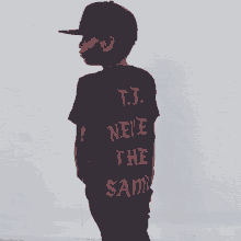 a young boy wearing a black shirt that says t.j. neve the sam