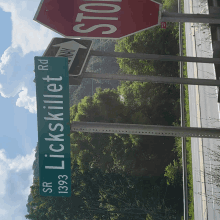 a green street sign for lickskillet rd