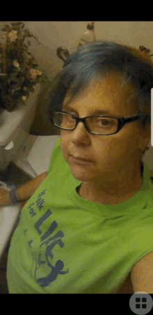 a woman with blue hair is wearing glasses and a green shirt that says hulk for life