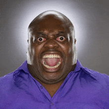 a man in a purple shirt making a funny face