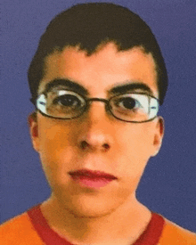 a young man wearing glasses and an orange shirt against a blue background