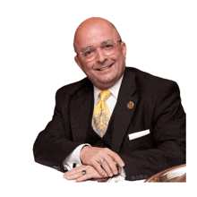 a man in a suit and tie with a gold pin on his lapel