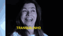 a woman with braces on her teeth is smiling with tranquilinho in yellow letters behind her