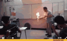 a man is standing in front of a classroom with a flame coming out of a stick