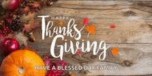 a thanksgiving greeting card with pumpkins , apples , leaves and pine cones on a wooden table