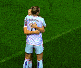 two female soccer players hugging each other with one wearing a number 1 jersey