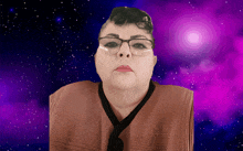 a woman wearing glasses looks at the camera in front of a purple background