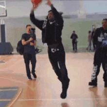 a man is jumping in the air while holding a basketball in his hands .