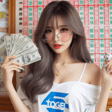 a woman wearing a shirt that says ' togel ' is holding a bunch of money