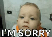 a baby is making a funny face and saying i 'm sorry .