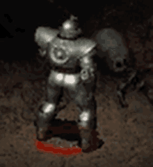 a statue of a man in armor is standing in the dirt in a dark room .