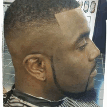 a man with a beard is getting a haircut at a barber shop .