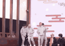 a group of young men are dancing on a stage in front of a screen that says t-series