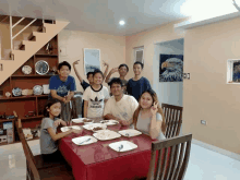 a group of people sitting around a table with one wearing a shirt that says adidas