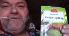 a man with a beard is holding a bag of spice that says xmeli-suneli