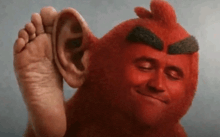 a red stuffed animal with a large ear and a foot