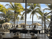 a view of the ocean from a restaurant with tables and chairs