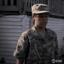 a young man in a military uniform is standing in front of a white house with showtime written on the bottom