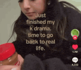 a woman is holding a jar of peanut butter and says just finished my k drama time to go back to real life .