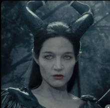 a woman with horns on her head looks at the camera with a serious look on her face