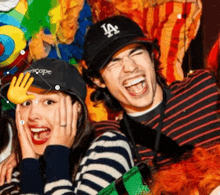 a man wearing a la hat and a woman wearing a striped shirt
