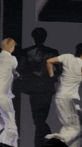 a group of people are standing next to each other on a stage and dancing .