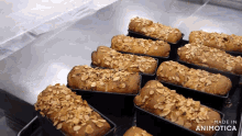 a bunch of loafs of bread are sitting on a table with the words made in animotica on the bottom right