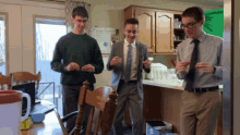 three men are dancing in a kitchen in front of a white board that says " a few dollars "