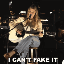 a woman singing into a microphone while sitting on a stool with the words i can 't fake it below her