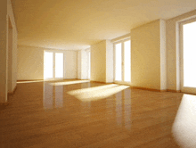 a large empty room with a wooden floor and lots of windows