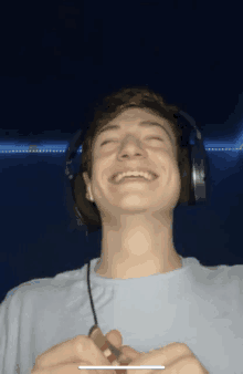 a young man wearing headphones is laughing and holding a lighter