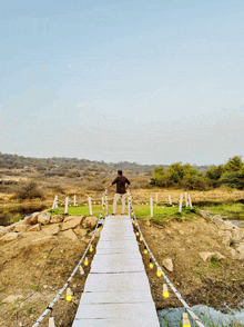 a man stands on a bridge over a lake