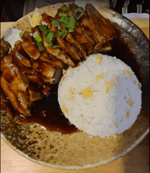 a plate of food with meat and rice on a table