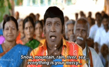 a man is standing in front of a crowd of people and saying snow , mountain , rain , river , sea