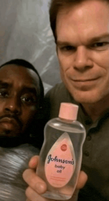 a man holds a bottle of johnson 's baby oil