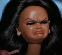 a close up of a barbie doll with a very angry look on her face