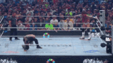 a wrestling match is being played in front of a crowd and the word universal is on the ring