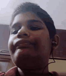 a boy wearing ear buds looks at the camera