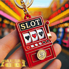 a person is holding a slot machine keychain