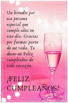 a pink birthday card with a glass of wine and the words feliz cumpleanos