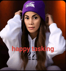 a woman wearing a purple beanie that says silk